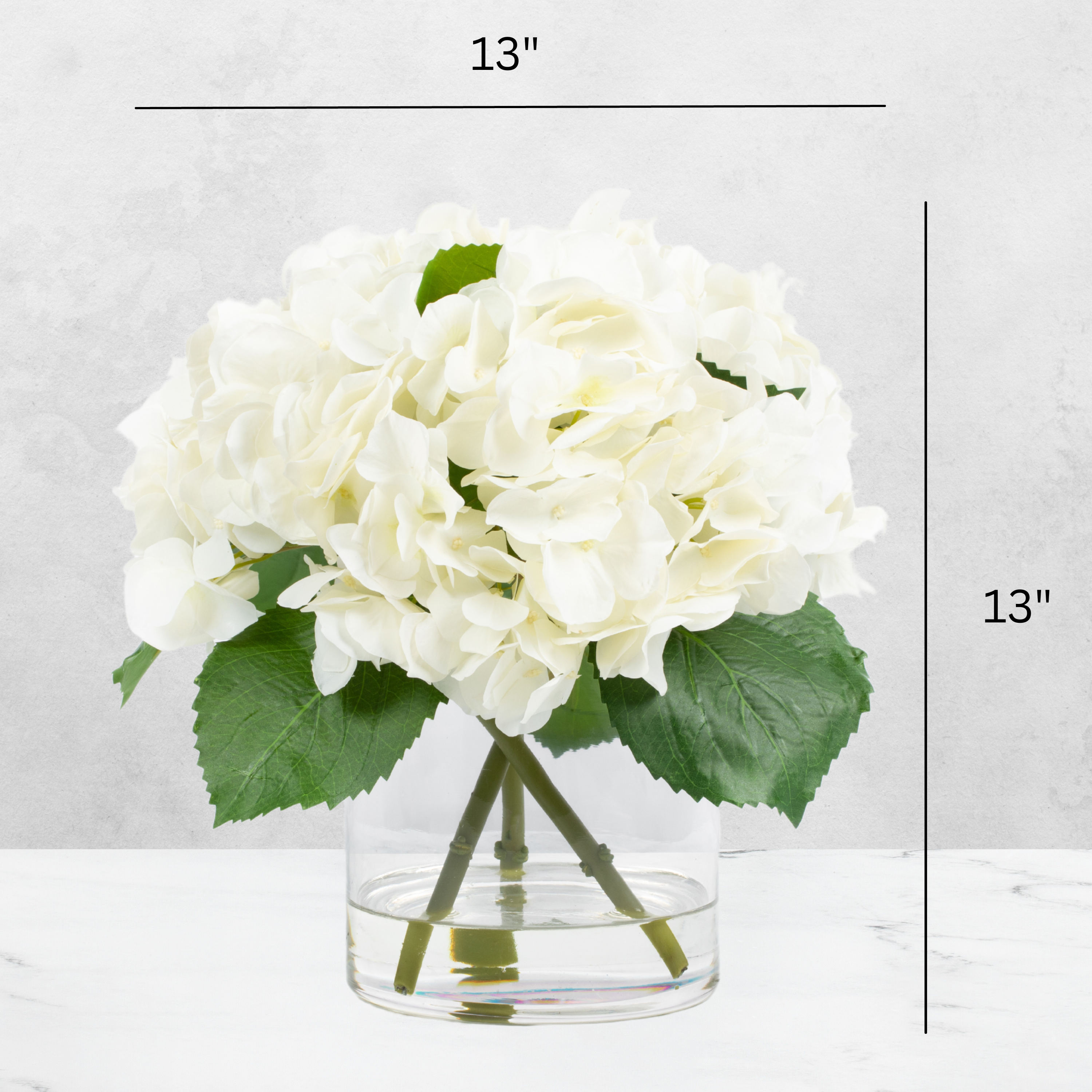 Faux hydrangea centerpiece arrangement in glass vase